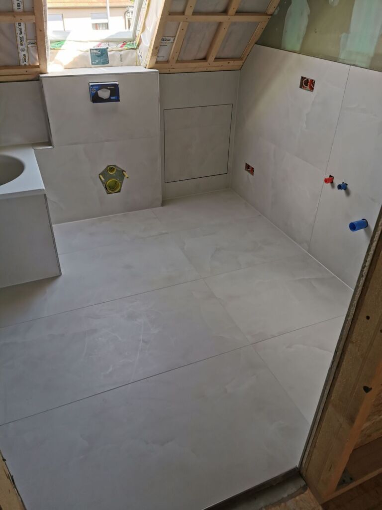 Ansicht der Wandfliesen Toilette und Waschisch Seite, Zugang zur Räumlichkeit verlegt mit FLiesen,