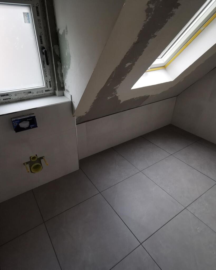 Ausgebautes Badezimmer mit Dachfenster, Fliesenboden und WC-Anschluss